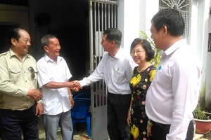 Bí thư Chi bộ khu phố 4 phường 13 quận 10 Lê Ngọc Minh (giữa) trò chuyện, thăm hỏi ông Nguyễn Văn Tiền