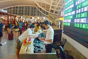 Du khách xem thông tin chuyến bay tại sân bay Ngurah Rai, Bali, Indonesia ngày 25-11-2017. Ảnh: REUTERS