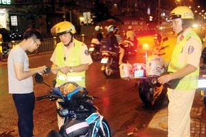 Cảnh sát giao thông - Công an quận 8 dừng xe xử phạt một trường hợp điều khiển xe máy không đội nón bảo hiểm. Ảnh: TUẤN VŨ