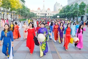Phụ nữ TP thướt tha trong tà áo dài trên phố đi bộ Nguyễn Huệ. Ảnh: CAO THĂNG