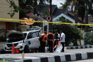 Cảnh sát Indonesia kiểm tra một chiếc xe được sử dụng bởi những kẻ tấn công bên ngoài trụ sở cảnh sát ở Pekanbaru, Riau. Ảnh: CNN