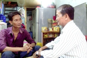 Chú Lê Thanh Vân (phải) thăm hỏi, trò chuyện với anh Lưu Quốc Hoa