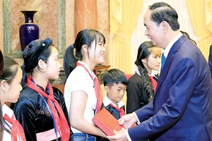 Chủ tịch nước Trần Đại Quang tặng quà các trẻ em có hoàn cảnh đặc biệt. Ảnh: TTXVN