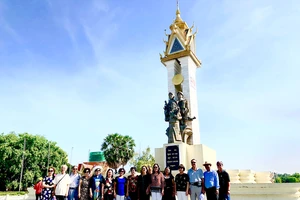 Các cựu sinh viên khóa 14 Khoa Ngữ văn, Đại học Tổng hợp Hà Nội chụp hình lưu niệm trước Tượng đài Quân tình nguyện Việt Nam ở Campuchia