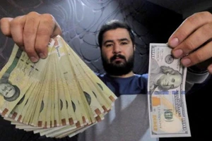 Một nhà đổi tiền ở thủ đô Tehran của Iran trưng tờ 100 USD (phải) và số tiền tương ứng bằng đồng Rial hôm 20-1-2016 - Ảnh: REUTERS