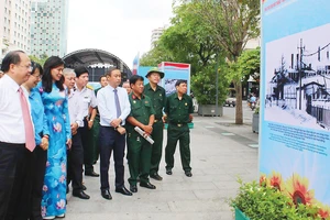 Phó Bí thư Thường trực Thành ủy TPHCM Tất Thành Cang cùng các đại biểu xem triển lãm