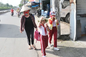 Học sinh một trường tiểu học ở huyện Hóc Môn trên đường về nhà sau giờ tan trường. Ảnh: THÀNH TRÍ