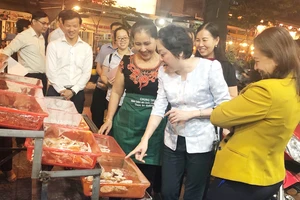 Bà Phạm Khánh Phong Lan, Trưởng ban Quản lý ATTP TPHCM tham quan cơ sở kinh doanh thức ăn đường phố tại phố ẩm thực Vĩnh Khánh.