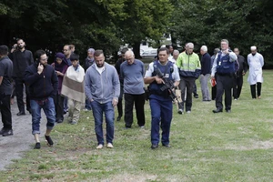 Cảnh sát đưa mọi người rời nhà thờ bị tấn công khủng bố ở TP Christchurch, New Zealand, ngày 15-3-2019. Ảnh: AP