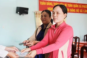 Hai người nhặt được vàng nhận tiền chia vàng từ chính quyền xã Phước Hưng.