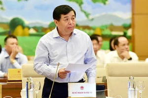 Bộ trưởng Bộ KH-ĐT Nguyễn Chí Dũng trình bày báo cáo về kinh tế - xã hội. Ảnh: TTXVN