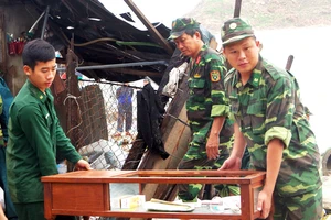Chiến sĩ bộ đội biên phòng tỉnh Bình Định hỗ trợ người dân khắc phục hậu quả sau bão. Ảnh: XUÂN HUYÊN