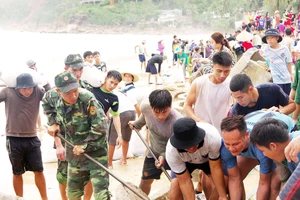 Lực lượng biên phòng, dân quân tự vệ và người dân nỗ lực sửa chữa kè biển xã Nhơn Hải, Bình Định. Ảnh: NGỌC OAI