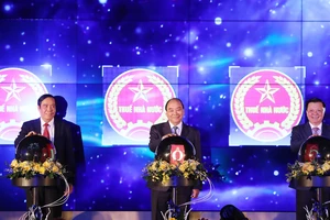 Thủ tướng Nguyễn Xuân Phúc thực hiện nghi thức hòa mạng các chi cục thuế khu vực vào hệ thống quản lý thuế chung cả nước. Ảnh: TTXVN