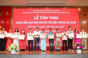 Ban Chỉ đạo vận động hiến máu tình nguyện thành phố Hà Nội tặng Giấy khen cho các gia đình có thành tích xuất sắc tham gia phong trào hiến máu tình nguyện. Ảnh: Thanh Tùng/TTXVN