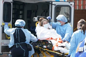 Nhân viên y tế chuẩn bị chuyển bệnh nhân mắc Covid-19 tới bệnh viện ở Brooklyn, New York (Mỹ). Ảnh: AFP/TTXVN