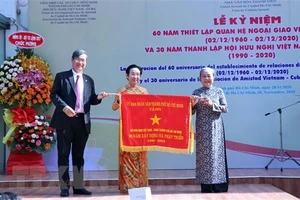 Ông Vương Đức Hoàng Quân, Chủ tịch Liên hiệp các tổ chức hữu nghị TPHCM, trao Cờ truyền thống của UBND TP tặng Hội hữu nghị Việt Nam-Cuba TPHCM. Ảnh: TTXVN