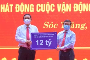 Ông Lê Văn Khanh, Chủ tịch Công ty XSKT Sóc Trăng (phải) trao 12 tỷ đồng hỗ trợ xây dựng nhà ở cho hộ nghèo 