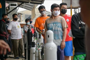 Người dân xếp hàng để nạp bình oxy tại một cửa hàng ở Jakarta, Indonesia, ngày 30-6-2021. Ảnh: AFP/TTXVN