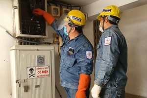 Nhân viên ngành điện thành phố kiểm tra hệ thống điện cho khách hàng