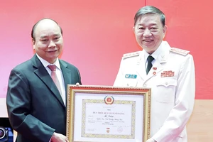 Chủ tịch nước Nguyễn Xuân Phúc trao tặng Huy hiệu 40 năm tuổi Đảng cho Đại tướng Tô Lâm, Bộ trưởng Bộ Công an. Ảnh: TTXVN