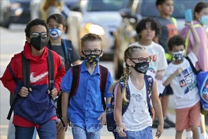 Các em nhỏ đeo khẩu trang phòng dịch Covid-19 khi ngày đầu tiên trở lại trường học sau thời gian dài giãn cách, tại Riverview, bang Florida (Mỹ) ngày 10-8-2021. Ảnh minh họa: AP/TTXVN