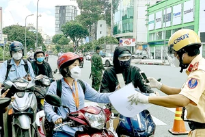 Kiểm tra giấy đi đường tại giao lộ Nguyễn Thị Minh Khai - Cách Mạng Tháng Tám, quận 3, TPHCM vào trưa 15-9. Ảnh: CHÍ THẠCH