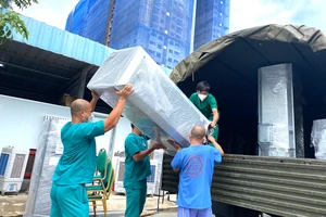 Nhân viên y tế Trung tâm Hồi sức Covid-19 do BV Bạch Mai quản lý đang vận chuyển đồ đạc trở về Hà Nội