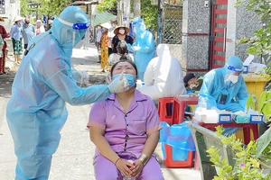 Nhân viên y tế lấy mẫu xét nghiệm Covid-19 cho người dân sống tại xã Bình Hưng, huyện Bình Chánh, TPHCM