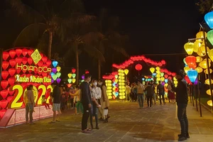 Du khách tham quan không gian chào đón năm mới được trang trí bởi đèn lồng tại TP Hội An (tỉnh Quảng Nam). Ảnh: XUÂN QUỲNH