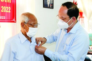 Phó Bí thư Thành ủy TPHCM Nguyễn Hồ Hải trao Huy hiệu 75 năm tuổi Đảng cho đồng chí Nguyễn Văn Hanh. Ảnh: DŨNG PHƯƠNG