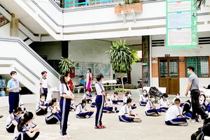 Học sinh Trường THCS Nguyễn Huệ, quận 4, TPHCM học thể dục chiều 21-2. Ảnh: CAO THĂNG