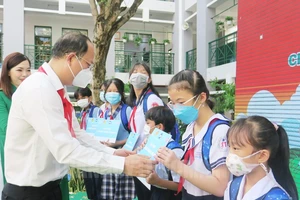 Phó Bí thư Thành ủy TPHCM Nguyễn Hồ Hải trao tặng học bổng cho các em thiếu nhi có hoàn cảnh khó khăn. Ảnh: hcmcpv