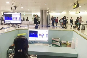 Nhân viên sân bay Tân Sơn Nhất kiểm tra màn hình hiển thị máy quét thân nhiệt đối với hành khách quốc tế đến Việt Nam. Ảnh: TTXVN
