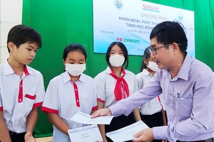 Đại diện Báo SGGP trao tặng học bổng cho học sinh khó khăn xã biên giới Phước Thiện, huyện Bù Đốp, tỉnh Bình Phước. Ảnh: VIỆT NGA