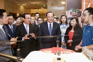 Bí thư Thành ủy TPHCM Nguyễn Văn Nên và Phó Thủ tướng Lào Sonexay Siphandone tham quan gian hàng giới thiệu sản phẩm tại diễn đàn. Ảnh: HOÀNG HÙNG