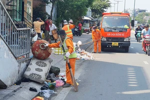 Đơn vị thu gom rác của thành phố thu dọn các bãi rác hoang trên đường Phạm Văn Đồng
