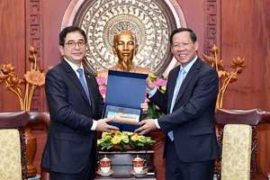 Chủ tịch UBND TPHCM Phan Văn Mãi tặng quà lưu niệm Chủ tịch Phòng Thương mại - Công nghiệp Indonesia Arsjad Rasjid. Ảnh: VIỆT DŨNG