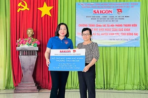 Phó Tổng Biên tập Báo SGGP Bùi Thị Hồng Sương trao biểu trưng các phần hỗ trợ tặng học sinh khó khăn Trường THCS Mã Đà