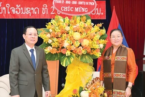 Phó Bí thư Thành ủy TPHCM Nguyễn Văn Hiếu tặng hoa chúc mừng Tổng Lãnh sự Lào Phimpha Keomixay nhân dịp Tết cổ truyền Lào. Ảnh: VIỆT DŨNG 