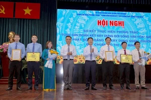 Lãnh đạo quận Phú Nhuận trao quyết định công nhận danh hiệu văn hóa cho các đơn vị. Ảnh: hcmcpv