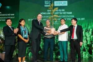 Ông Mark Schneider, Giám đốc điều hành Tập đoàn Nestlé (thứ 3 từ trái sang) trao cây đến người nông dân (thứ 4 từ trái sang), khởi động dự án nông lâm kết hợp tại Việt Nam