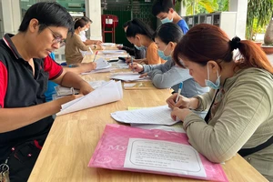 Phụ huynh làm thủ tục cho con nhập học lớp 6 Trường THCS Chánh Hưng, quận 8, TPHCM. Ảnh: CAO THĂNG 
