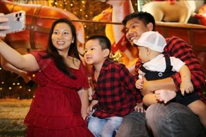 Một gia đình nhỏ ghi lại khoảnh khắc hạnh phúc trong đêm Giáng sinh. Ảnh: DŨNG PHƯƠNG