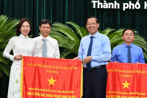 Chủ tịch UBND TPHCM Phan Văn Mãi trao cờ thi đua cho đơn vị xuất sắc. Ảnh: VIỆT DŨNG