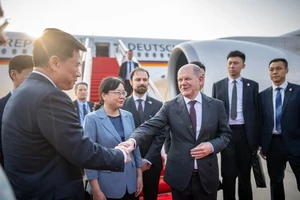 Thủ tướng Đức Olaf Scholz (phải) đang bắt tay với một quan chức Trung Quốc khi đến TP Trùng Khánh (Trung Quốc) hôm 14-4. Ảnh: BLOOMBERG