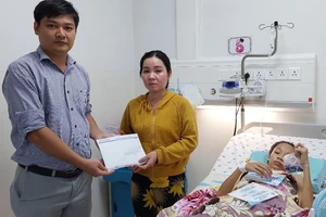 Đại diện Báo SGGP trao số tiền của bạn đọc hỗ trợ cho gia đình em Nguyễn Trần Anh Thư