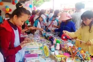 Đông đảo phụ huynh và học sinh đến tham quan và mua sắm hàng hóa tại gian hàng của Công ty Fahasa tại Ngày hội giới thiệu sản phẩm bình ổn thị trường 2016
