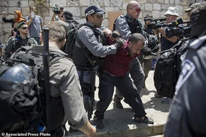 Cảnh sát Israel bắt giữ một người Palestine sau khi ông này kêu gọi các giáo sĩ cầu nguyện trên phố thay vì tại nhà thờ Hồi giáo Al Aqsa, tại thành phố cổ Jerusalem, ngày 19-7. Ảnh: AP