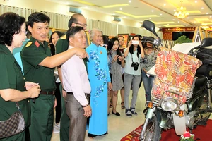 Họa sĩ Đặng Ái Việt (áo dài) giới thiệu chiếc xe Cánh én, “người bạn” sát cánh bên bà trong những chuyến đi